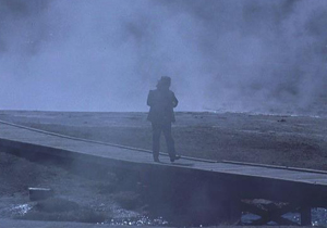 hombre solo en un puente sobre la niebla